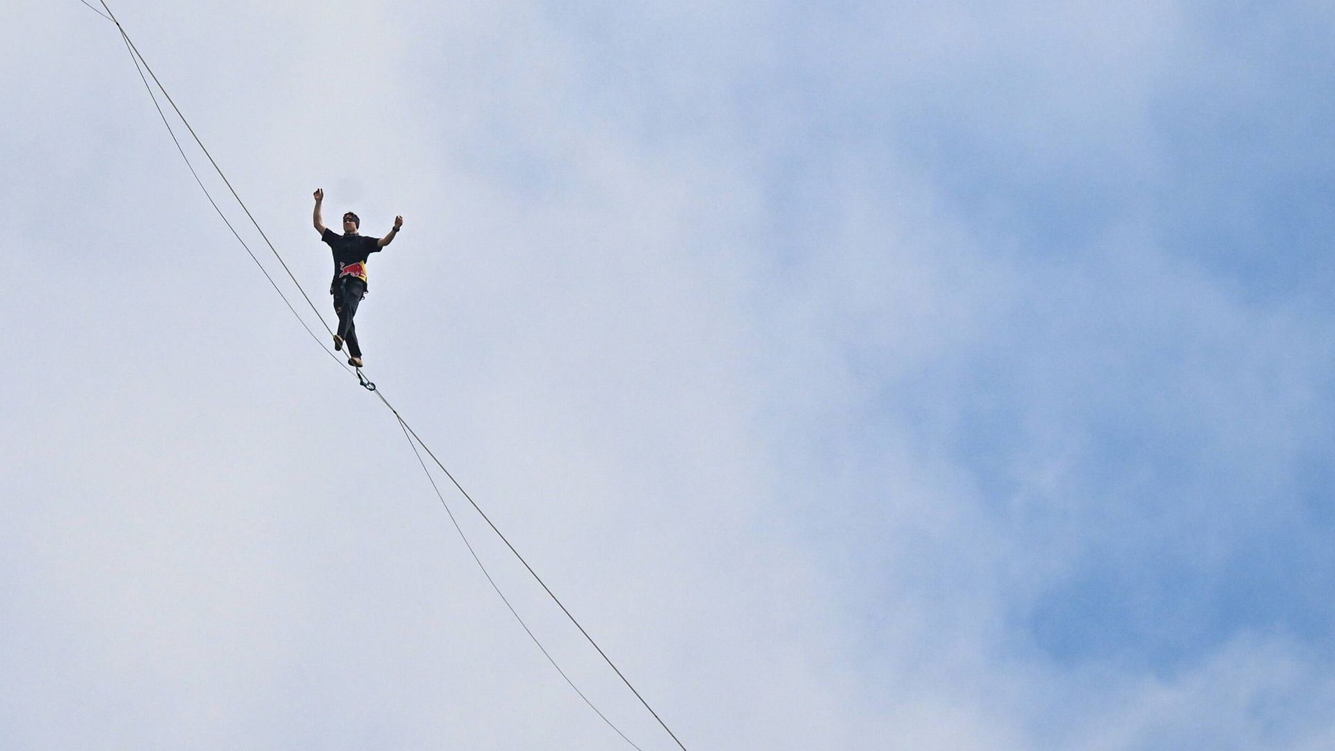 
                                Estonian slackliner Jaan Roose walks on a 2 cm-wide line 180 meters above the ground between the two tallest buildings in Warsaw, Poland
                            