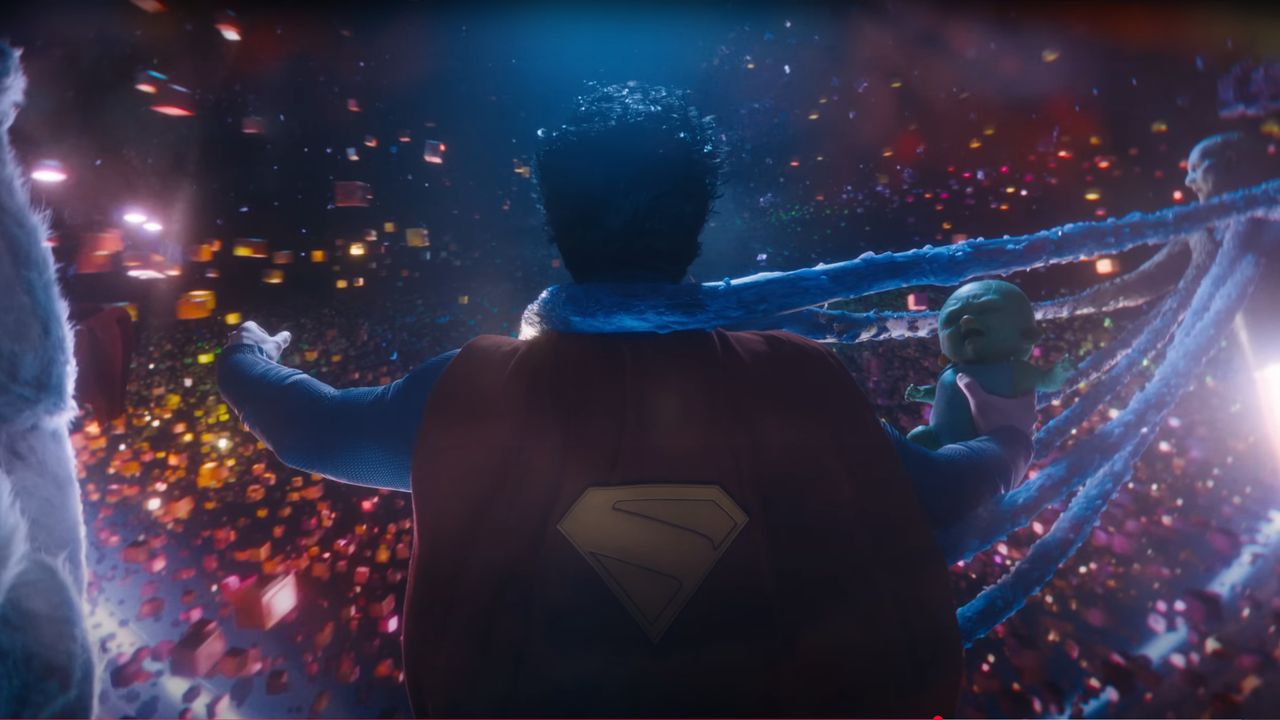 A red-caped superhero in a cosmic void holding a green alien baby