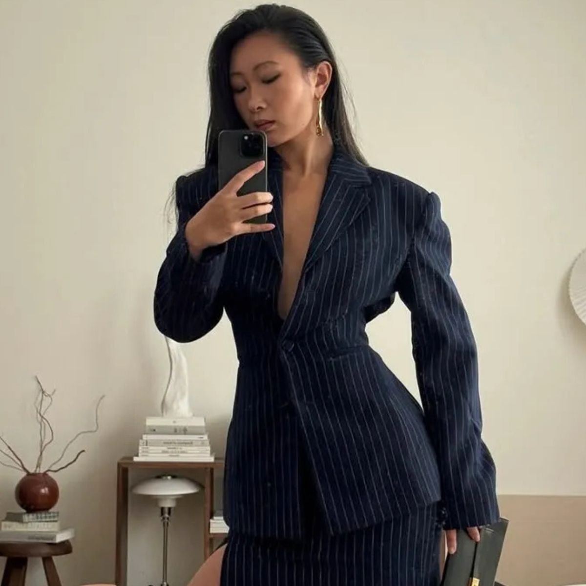 @thecarolinelin wearing a navy pinstripe outfit with side-parted hair