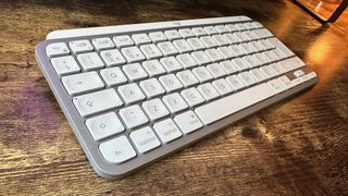 The Logitech MX Keys Mini for Mac keyboard on a wooden desk