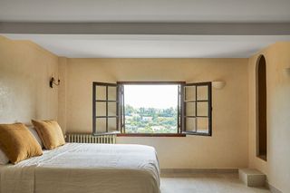 Gold pillow and linen bedsheets in this calming bedroom