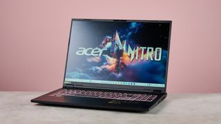 Three-quarter view of Acer Nitro 18 AI open on desk, with pink wall in background