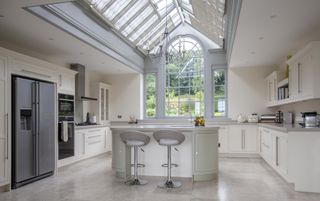 a kitchen conservatory extension through the central volume of a kitchen