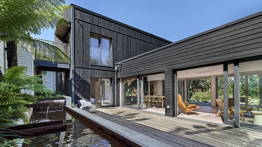 Contemporary dark grey timber bespoke home with swimming pool and greenery
