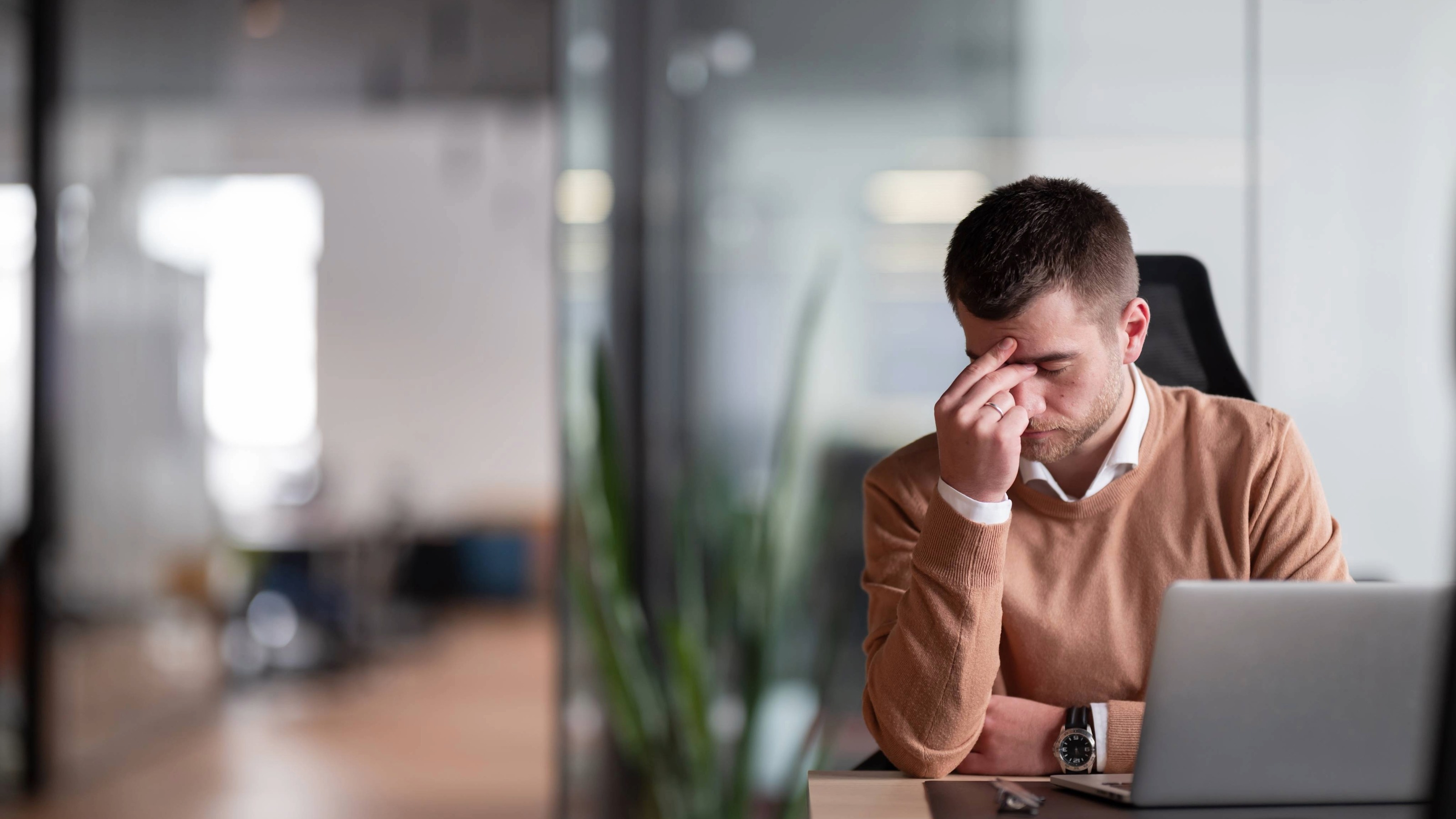 Young tired office worker at his desk