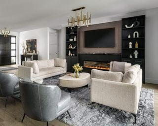 Living room with ivory colored sofas facing on gray rug, gray accent chairs and coffee table