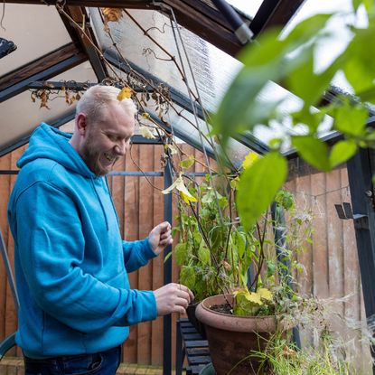 A smiling man in a greenhouse