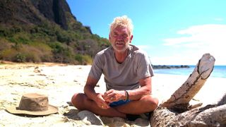 Phillip Schofield sitting on a deserted beach for Cast Away