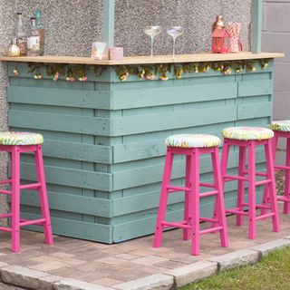garden with wooden bar bar stools and floral garland
