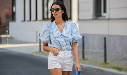 Alyssa Cordes is seen wearing white shorts Levis, blue gingham checkered top Envii, Adidas sneaker, Prada bag in blue, sunglasses Mango on June 14, 2021 in Berlin, Germany.