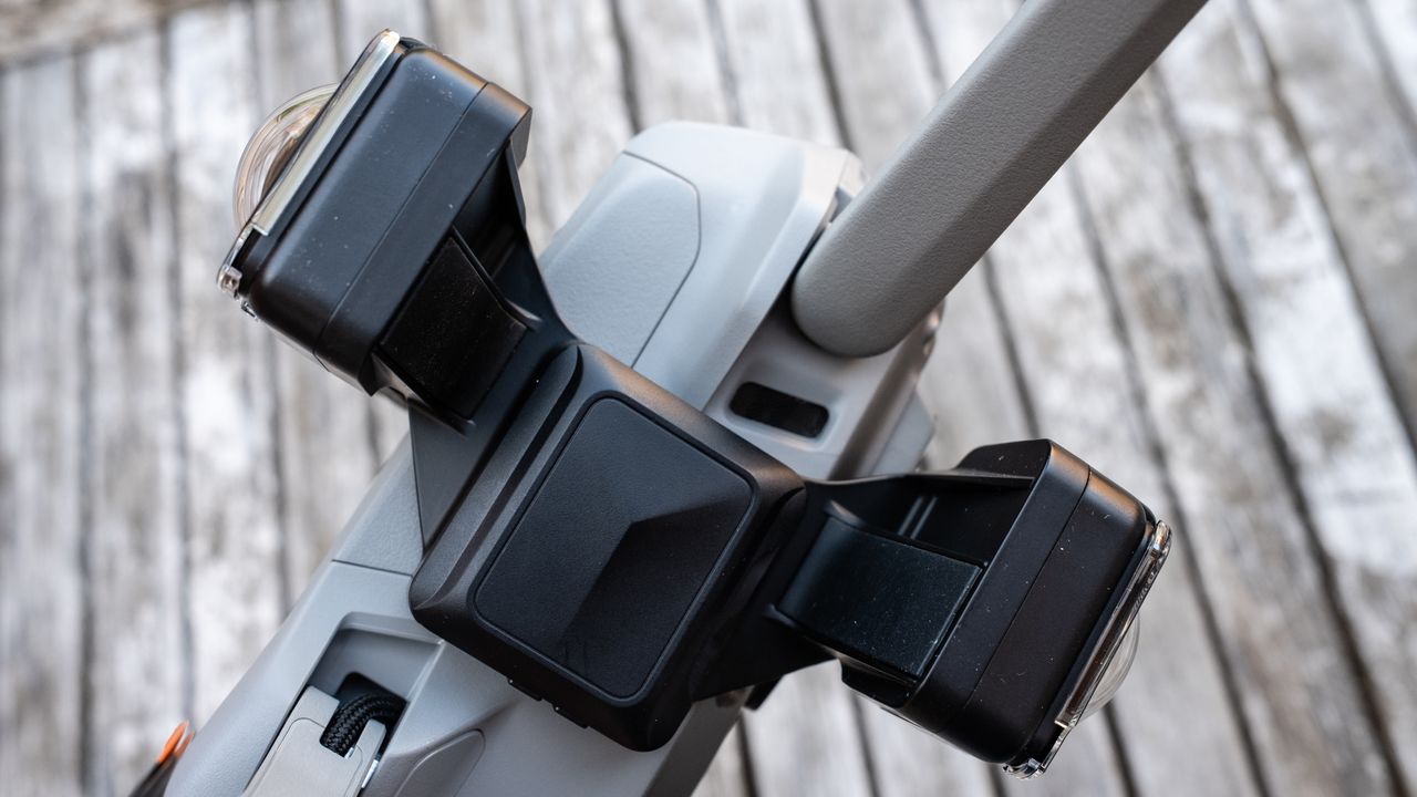A DJI drone on a wooden table connected to the Insta360 Sphere 360 camera