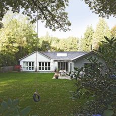 exterior of bungalow with green lawn and tire swing