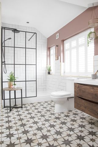 Bathroom with patterned tile flooring, Crittal-style shower screen, white WC and wood vanity unit and pink walls