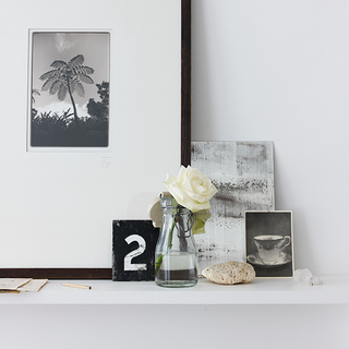 white wall with white shelve and rose with glass jar