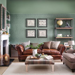living area with brown leather sofa and green wallpaper wall