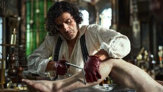 Oscar Isaac's Victor Frankenstein chopping up a leg in Frankenstein 