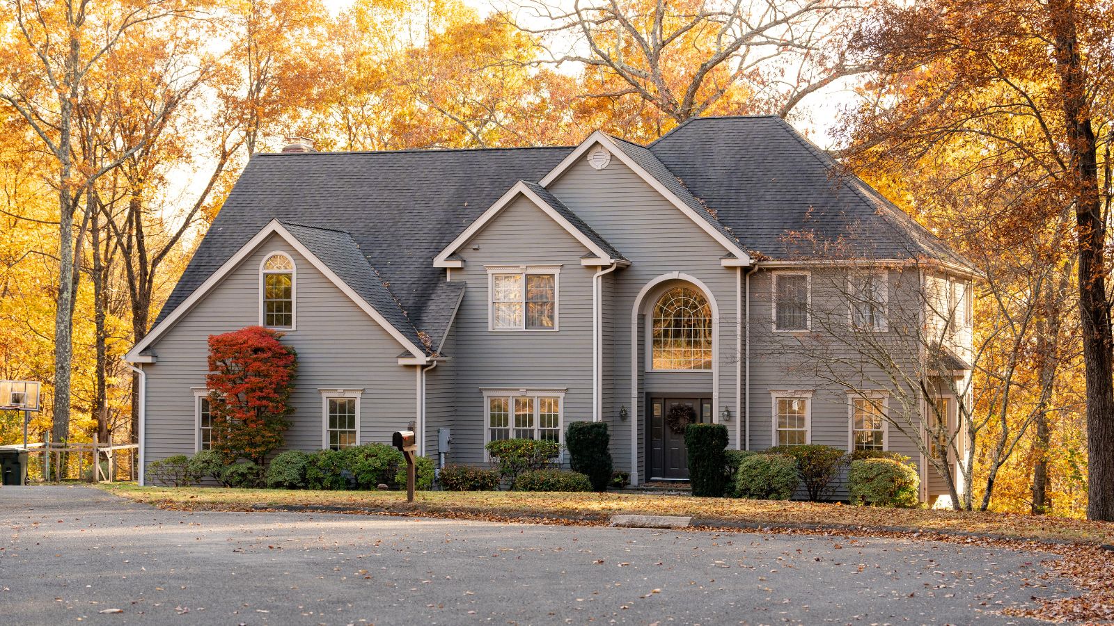 A front view of a beautiful American house and autumn leaves in the background