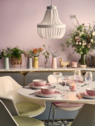 pastel pink dining room with pastel accessories and tableware, white beaded chandelier