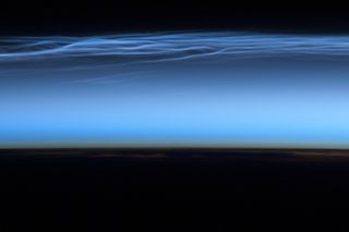 A photograph of polar mesospheric clouds taken from the International Space Station in 2012.