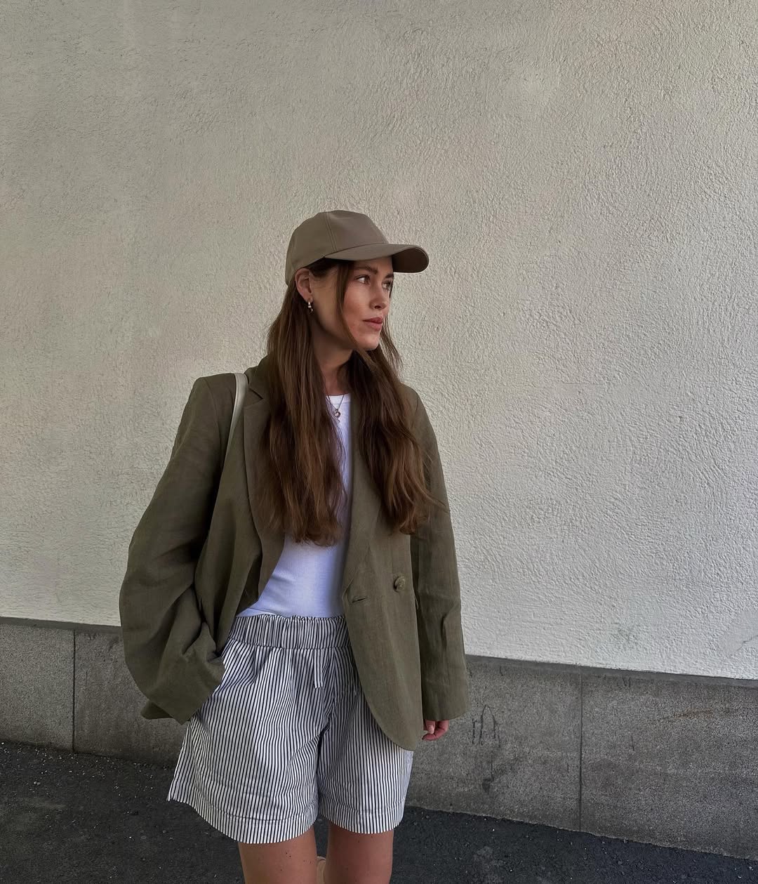 Annabel in linen blazer, baseball cap and striped shorts