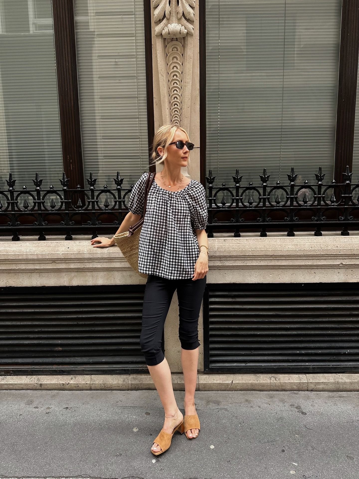 Influencer @chloekathbutler wears a short sleeve gingham blouse with capri pants and suede mule heels.