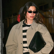 Hailey Bieber is spotted in NYC wearing a trench coat and an oversized clutch.