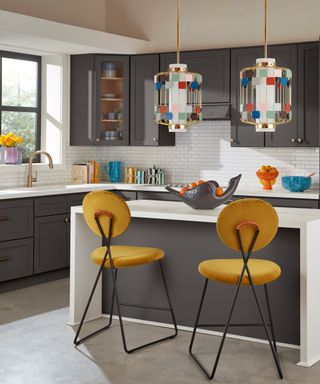 Pendant lighting hanging over a white kitchen island with yellow bar stools