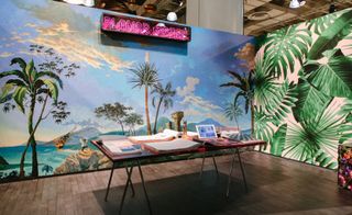 A view of Flavor Paper's vibrant ICFF booth, featuring art director Wayne White's cheeky pastoral mural-cum-wallpaper