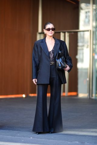 woman wearing black blazer, black trousers, and lace top