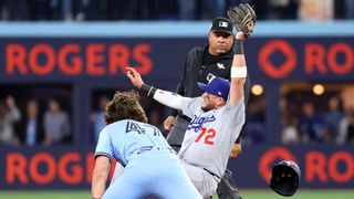 The Los Angeles Dodgers' Miguel Rojas forces out the Toronto Blue Jays' Addison Barger in the 2025 World Series at Rogers Center