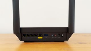 Linksys Hydra Pro 6 router on a wooden desk.