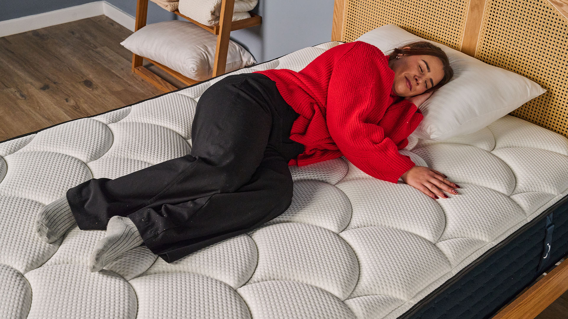 A closeup of a woman lying in a side sleeping position on the DreamCloud Luxury Hybrid Memory Foam mattress in a bedrom