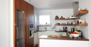 small white kitchen with wooden cabinets and open shelves showing how to use awkward corners with shelves as a great small kitchen storage ideas