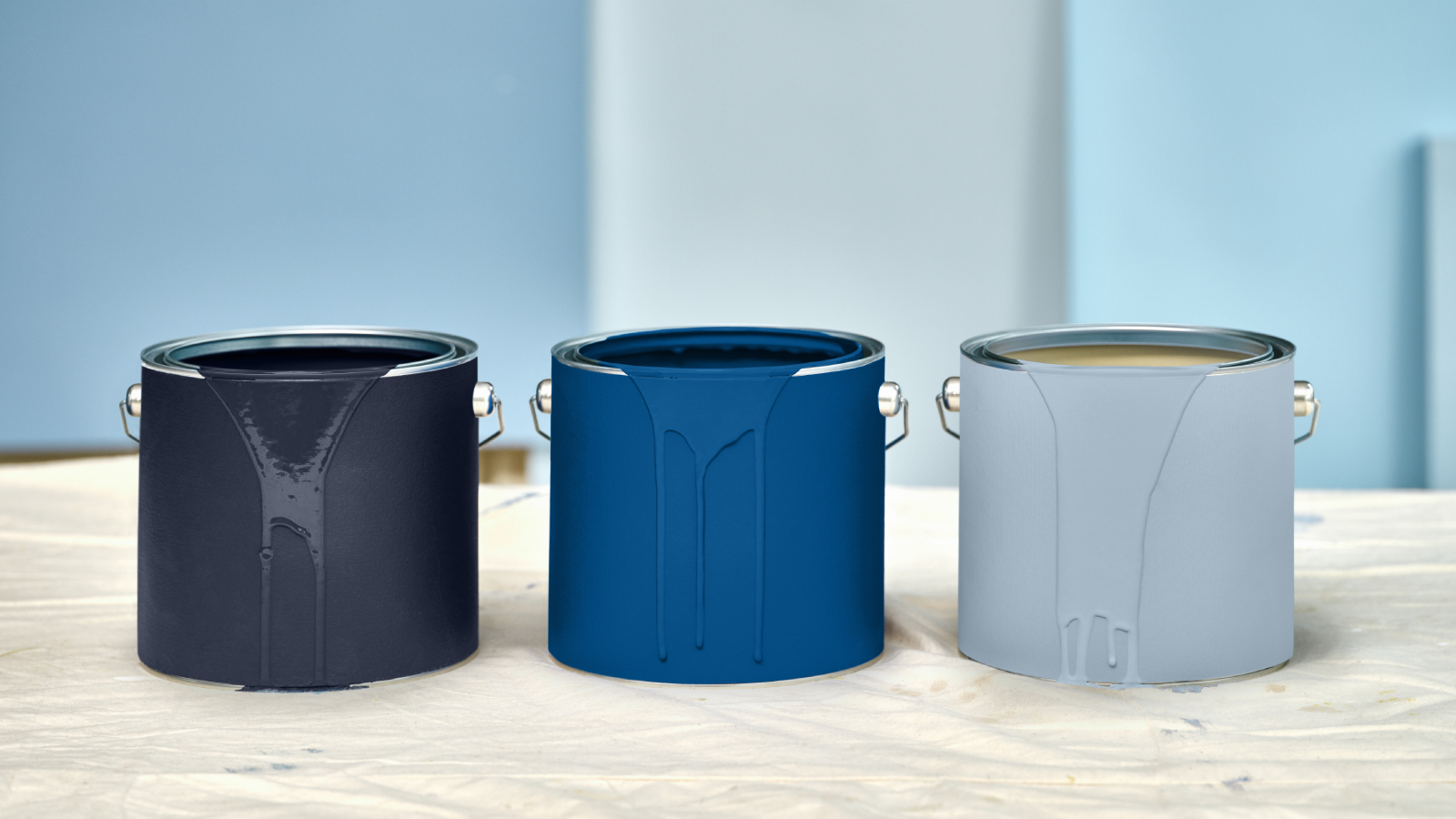 3 open tins of different shades of blue paint 