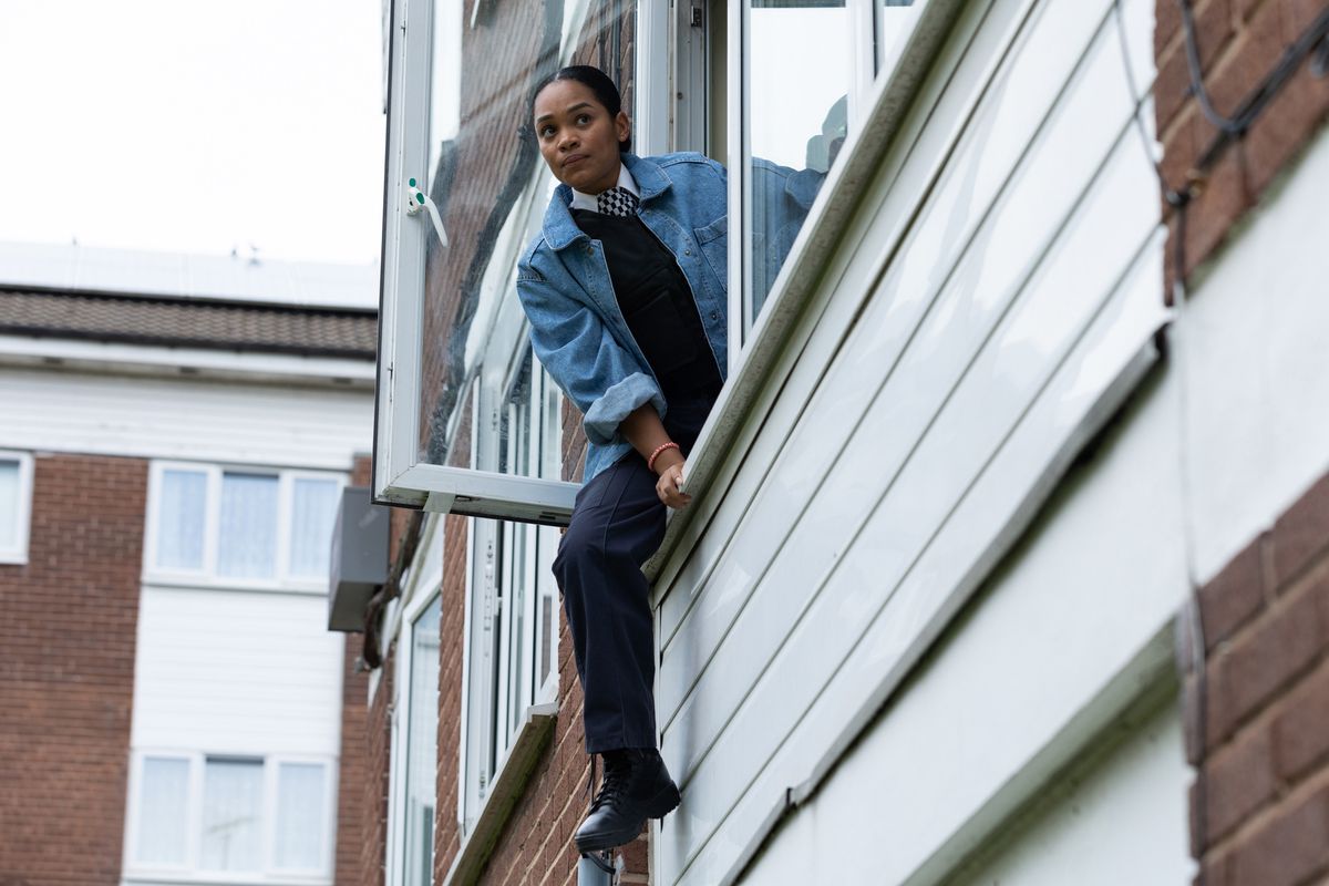 Lizzie climbing out of a window.