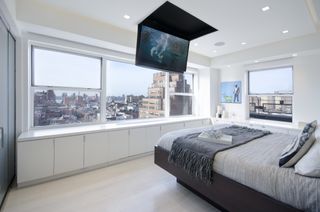 apartment style bedroom with drop down TV from ceiling