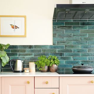 kitchen-diner with pink cabinets and tiled splashback