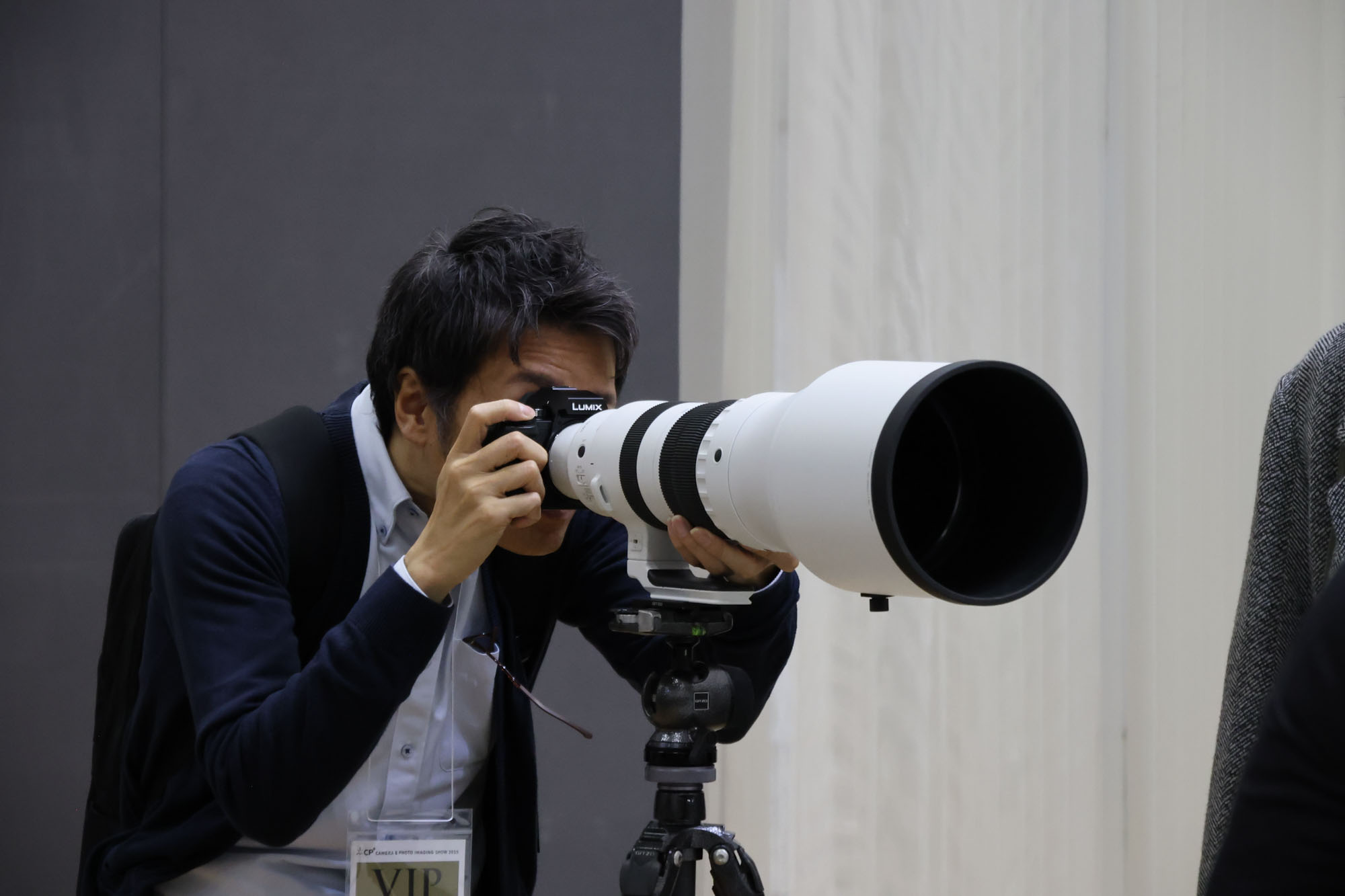 Person holding the Sigma 300-600mm F4 lens at the CP+ 2025 photography show