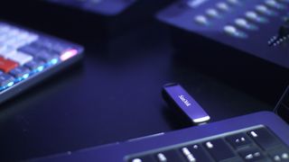 A promotional photograph of a Sandisk USB flash drive protruding from a laptop.