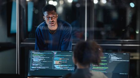 Two cybersecurity professionals in a modern office.