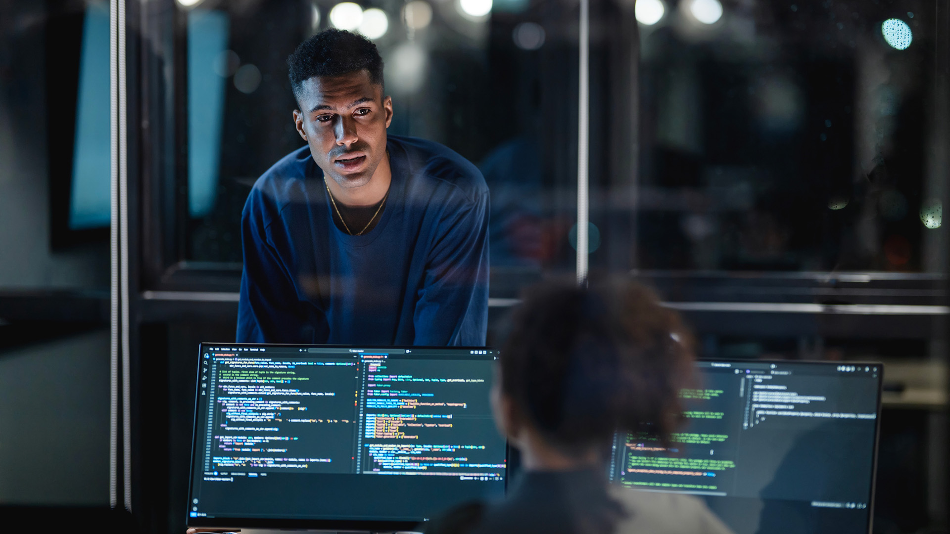 Two cybersecurity professionals in a modern office.