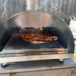 pizza cooking in Woody pizza oven using wood fuel