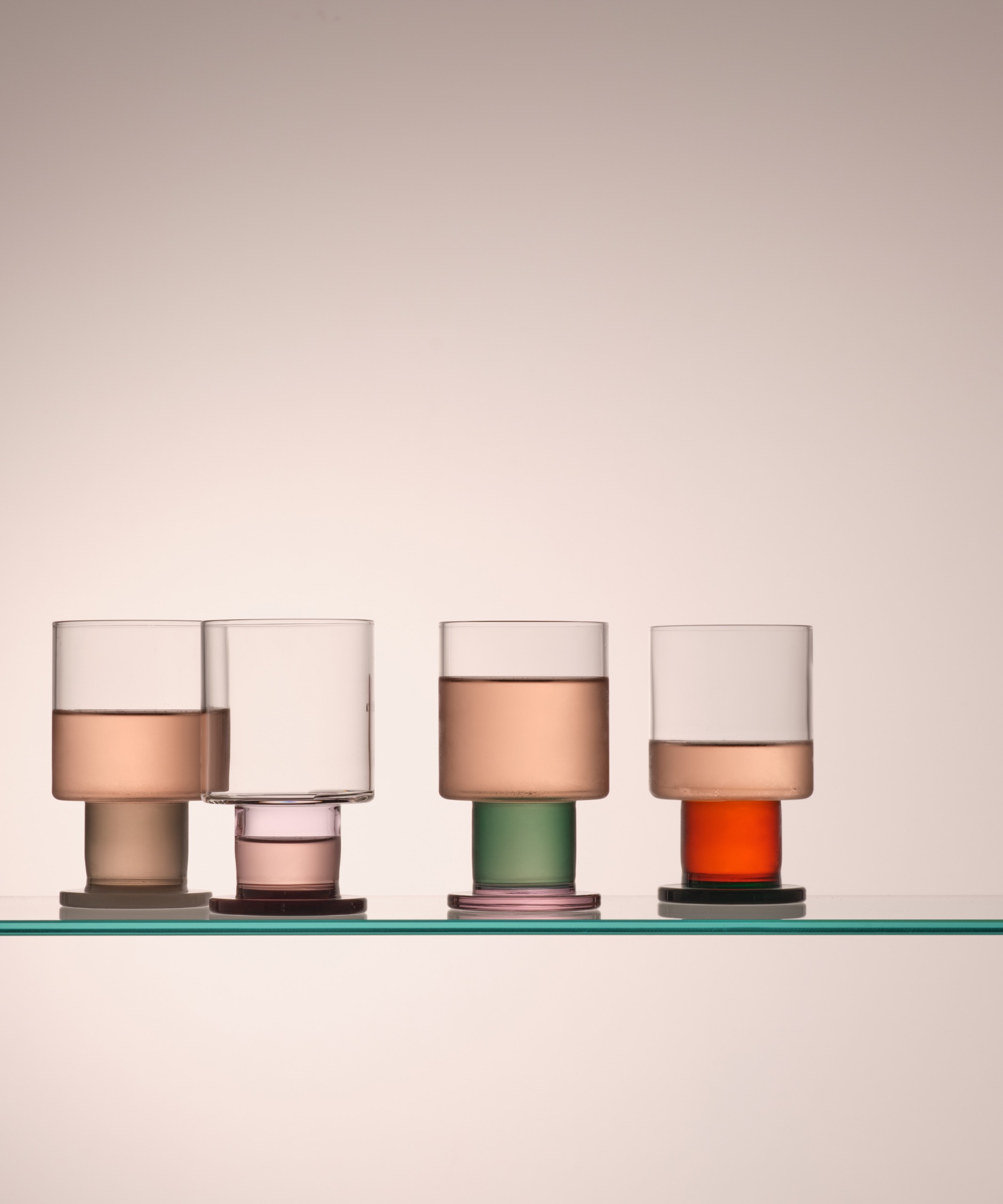 a selection of thick wine glasses in colors on a plain background