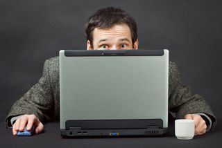 Man peering over computer
