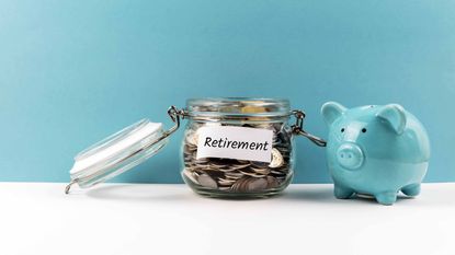 blue piggybank next to clear jar with coins with retirement note posted on it