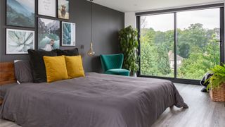 dormer loft bedroom with large floor to ceiling windows and grey, blue and yellow colour scheme
