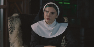 Bella Thorne dressed as a nun in Habit, looking quizzically