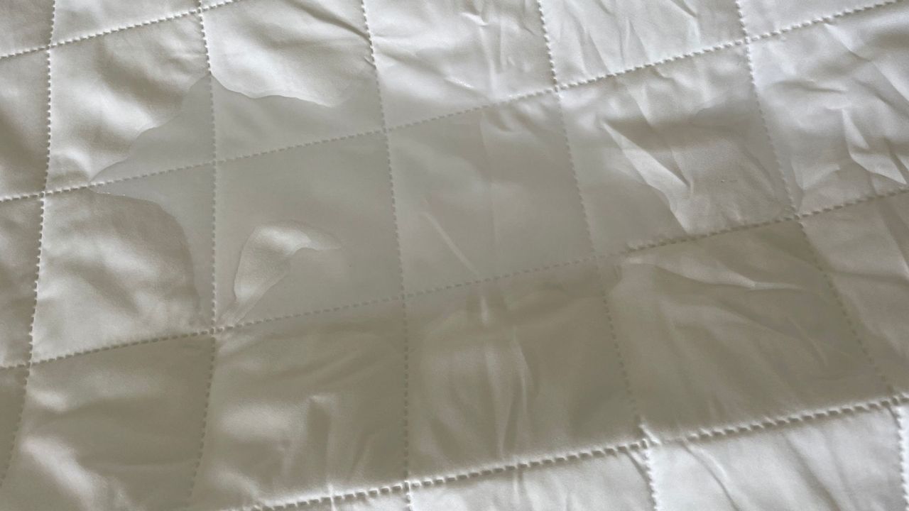 OTTY Waterproof Mattress Protector with a water puddle on it