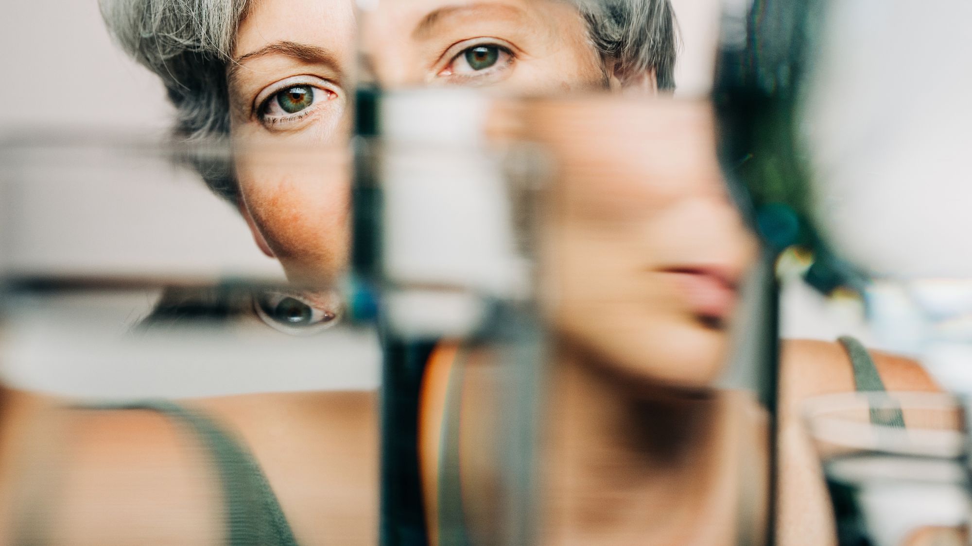 Portrait of female through glass of water. - stock photo
