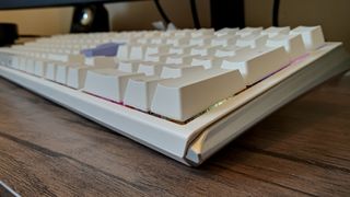A white Ducky One 3 mechanical keyboard on a wooden desk.
